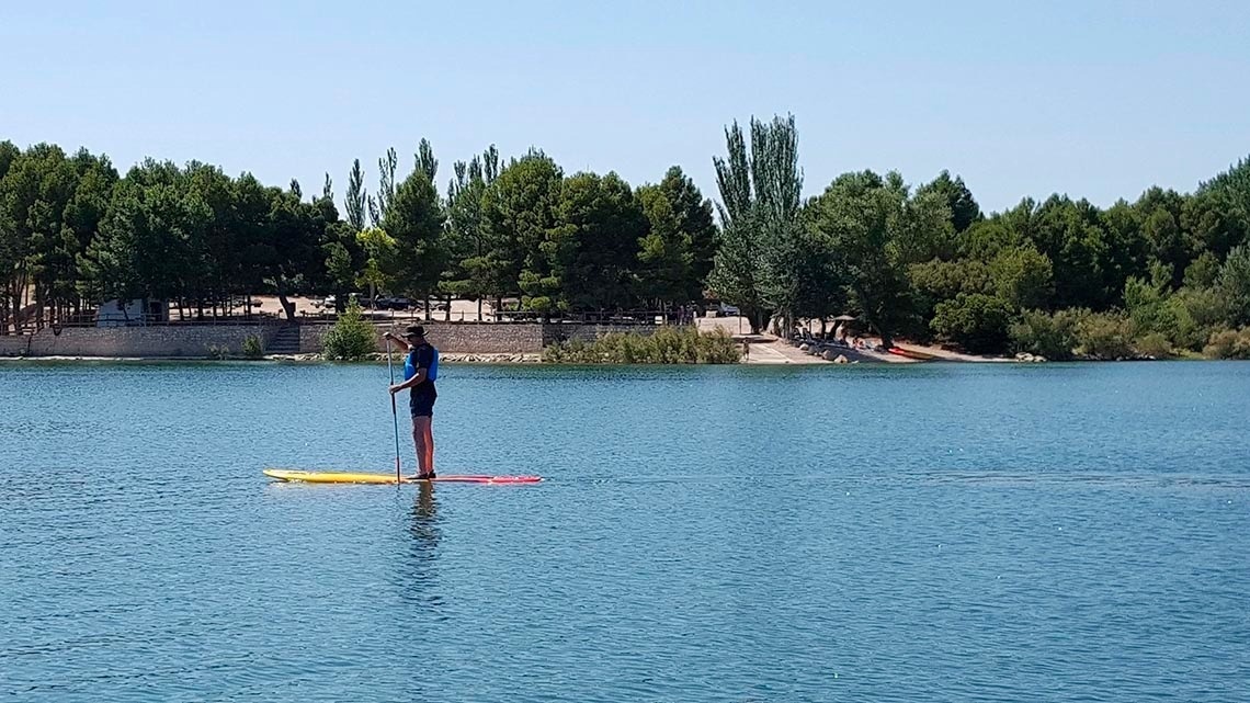 une personne sur une planche à pagaie dans un lac