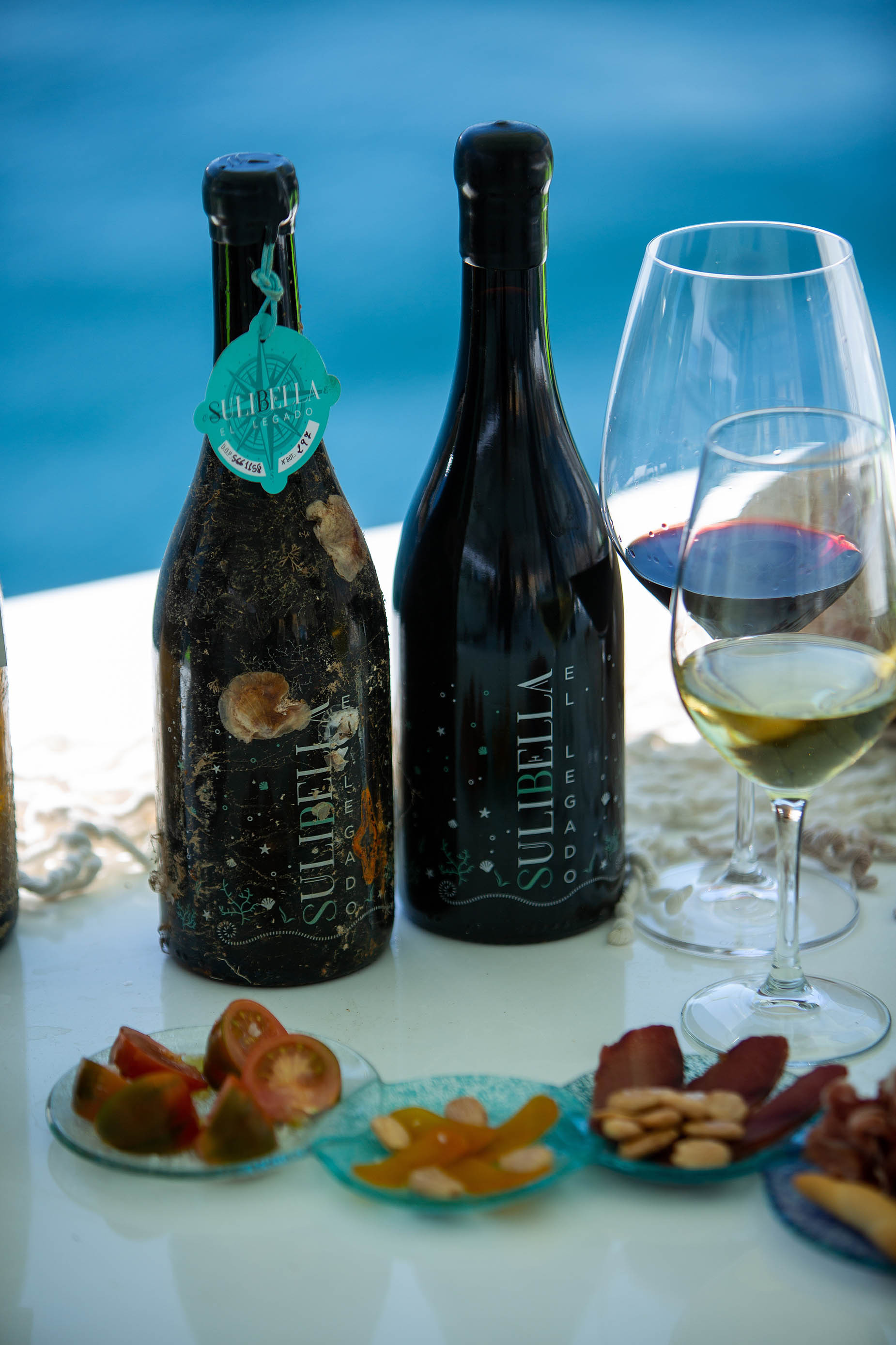 Weinprobe Taiga: Corporativa am Meer mit zwei Flaschen Wein und Gläsern