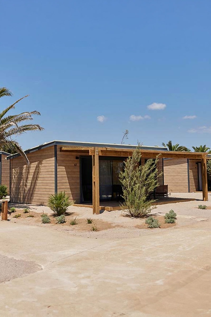 una casa de fusta amb un banc a l' avinguda