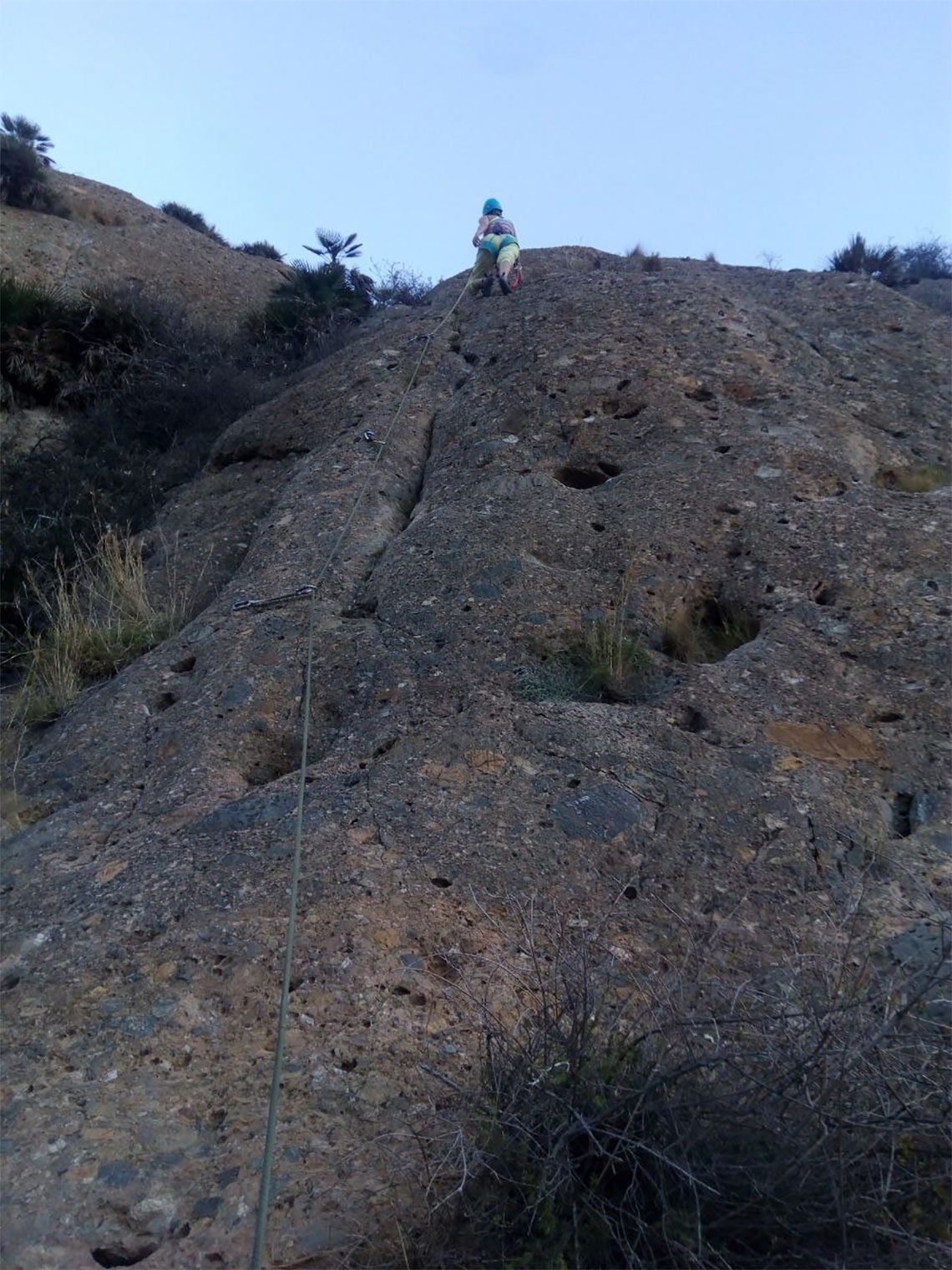 una persona sube una pared de roca con una cuerda