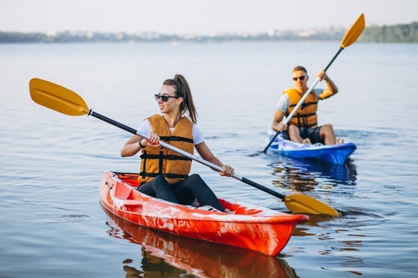 un homme et une femme sont en kayak sur un lac