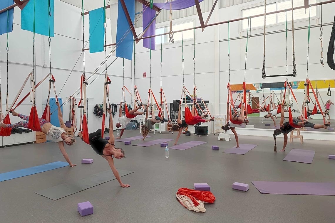 a group of people are doing aerial yoga in a gym