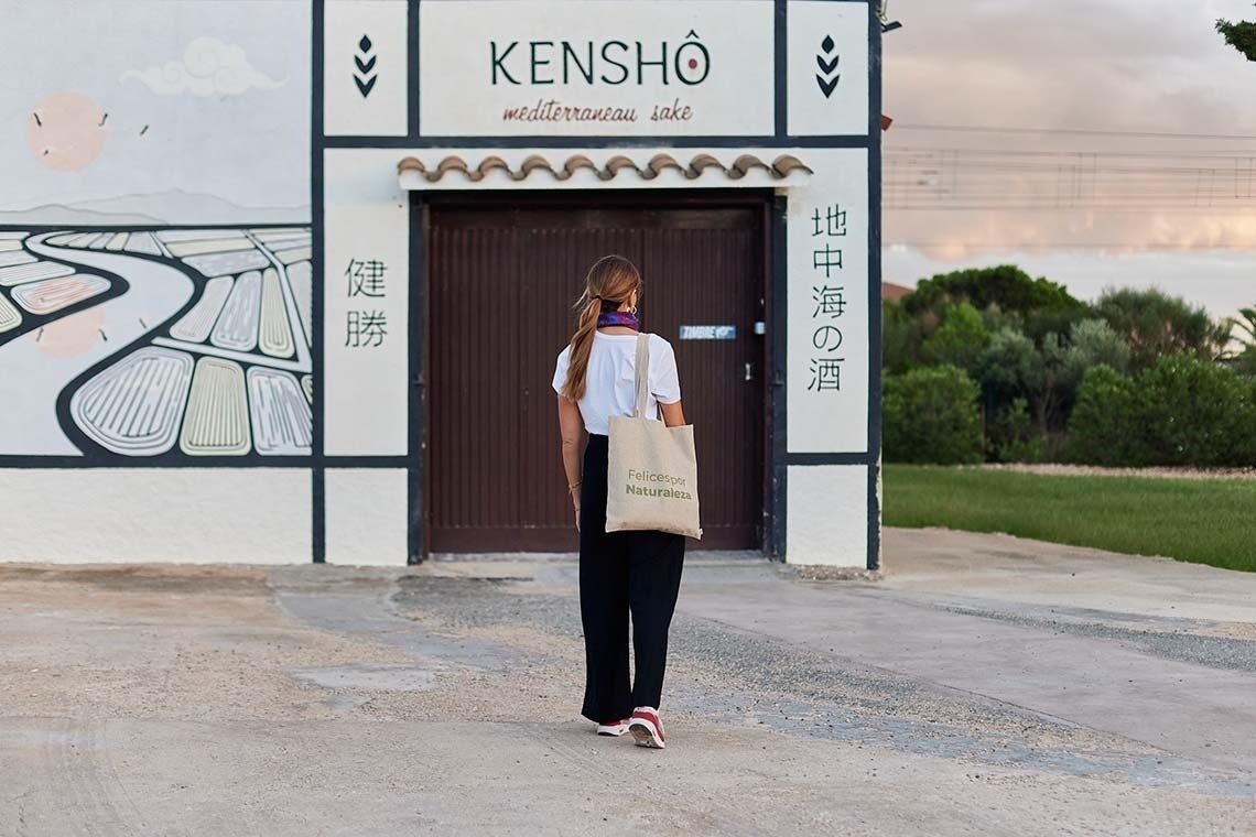 een vrouw loopt voor een kensho-gebouw