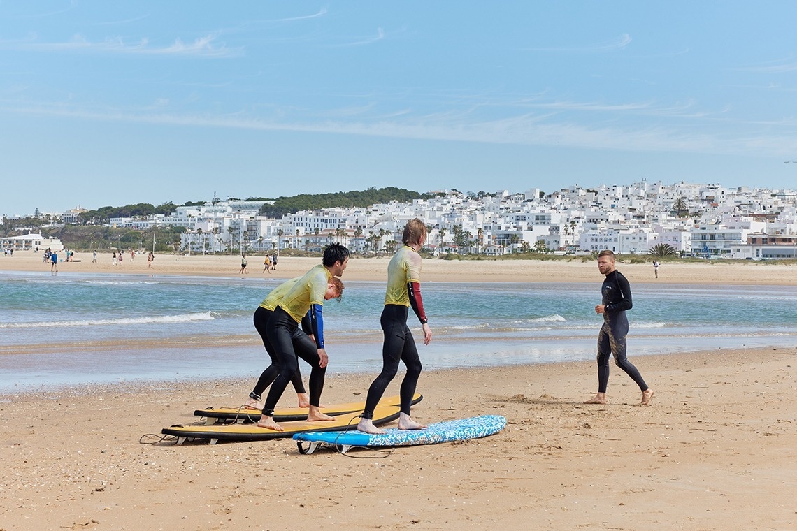 un grupo de surfistas se preparan para surfear en la playa