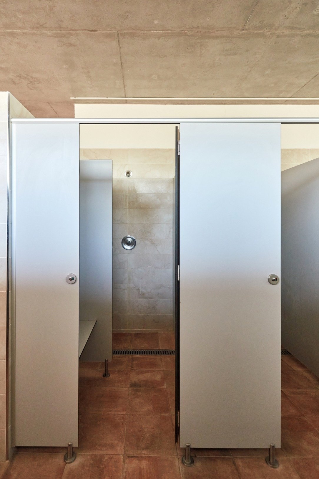 a bathroom with white walls and brown tile floors