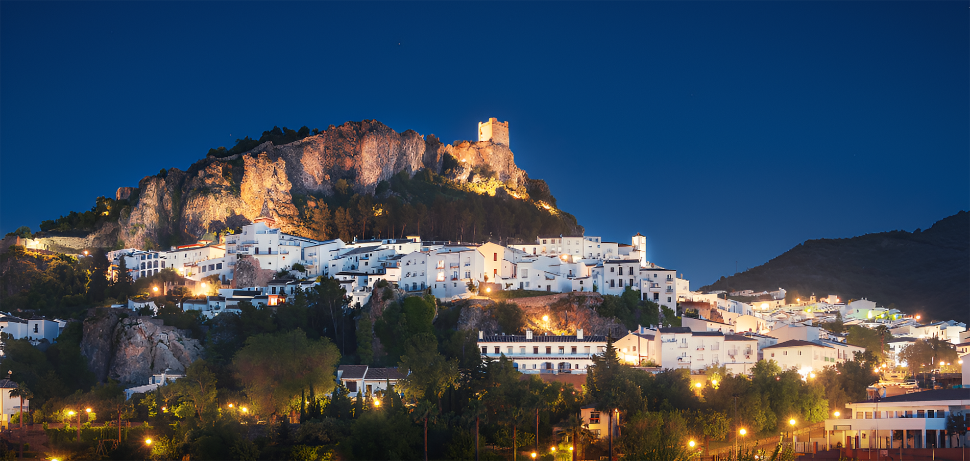 a small town sits on top of a hill at night