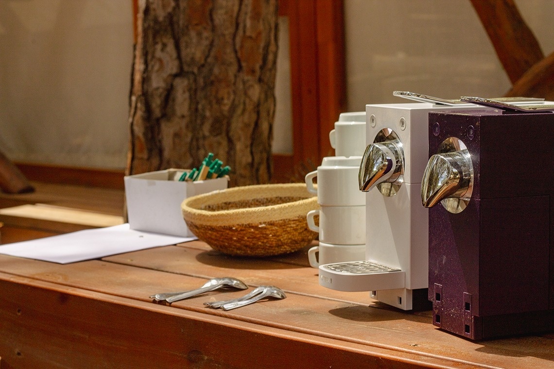 a purple coffee maker sits next to a white coffee maker