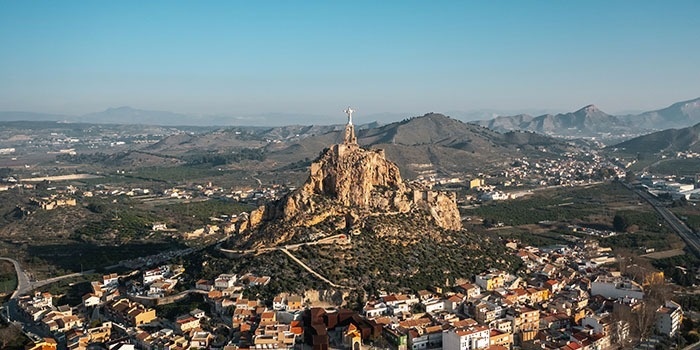 una ciudad con una estatua de jesús en la cima de una montaña