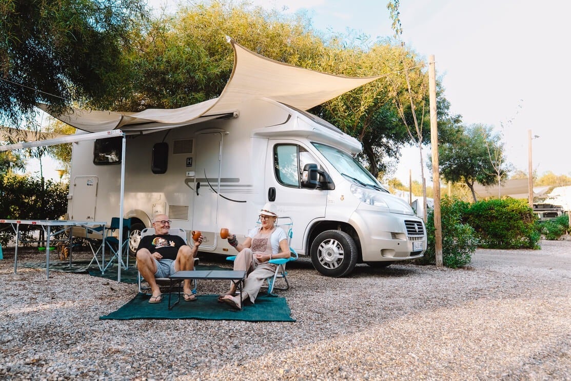 Couple enjoying drinks at TAIGA Almería Playa campsite, Spain. Explore TAIGA Resorts.