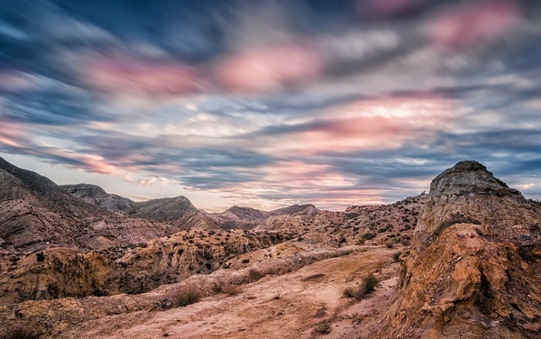een landschap met bergen en een bewolkte hemel