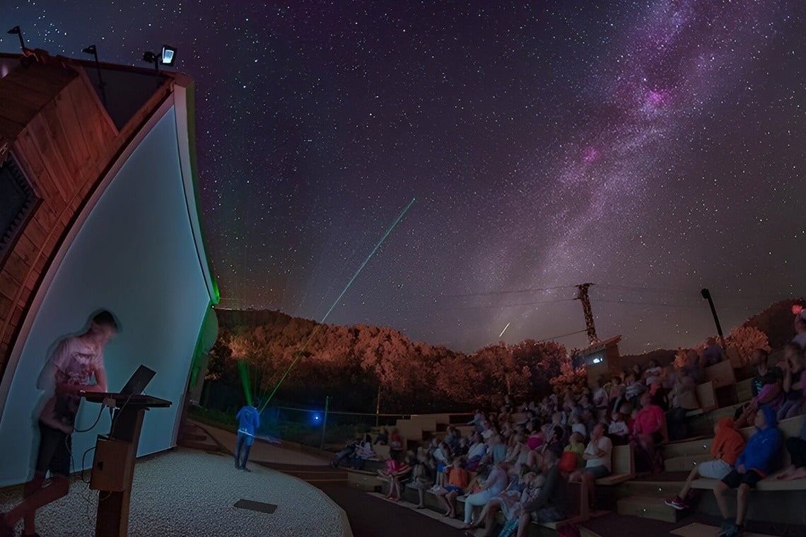 two little girls are running in the grass holding hands