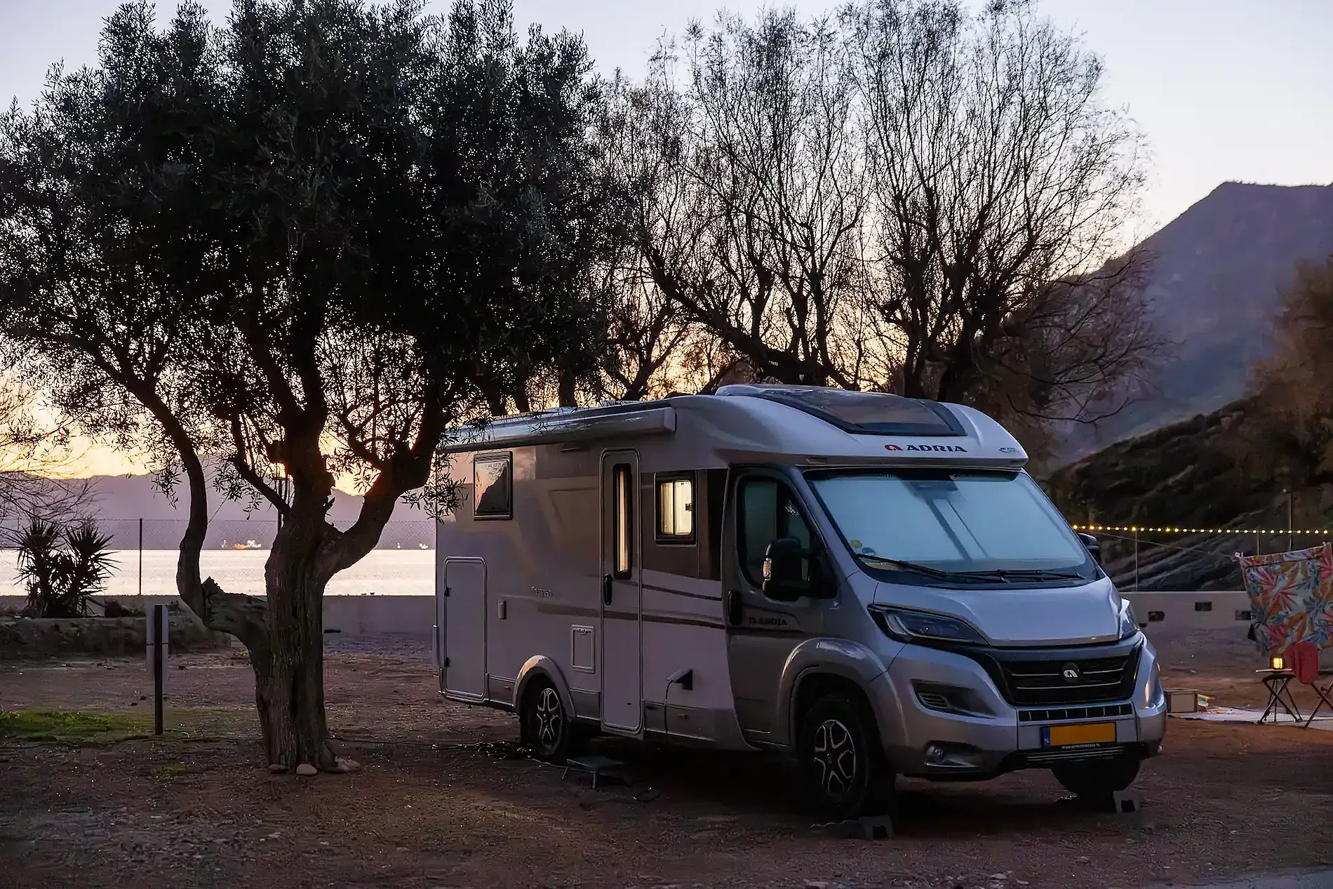 Autocaravana de lujo en sitio de camping con vista al mar y montañas. 