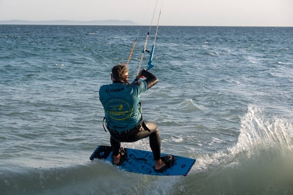 Deportista haciendo kitesurf en Tarifa, ideal para retiros corporativos Taiga.