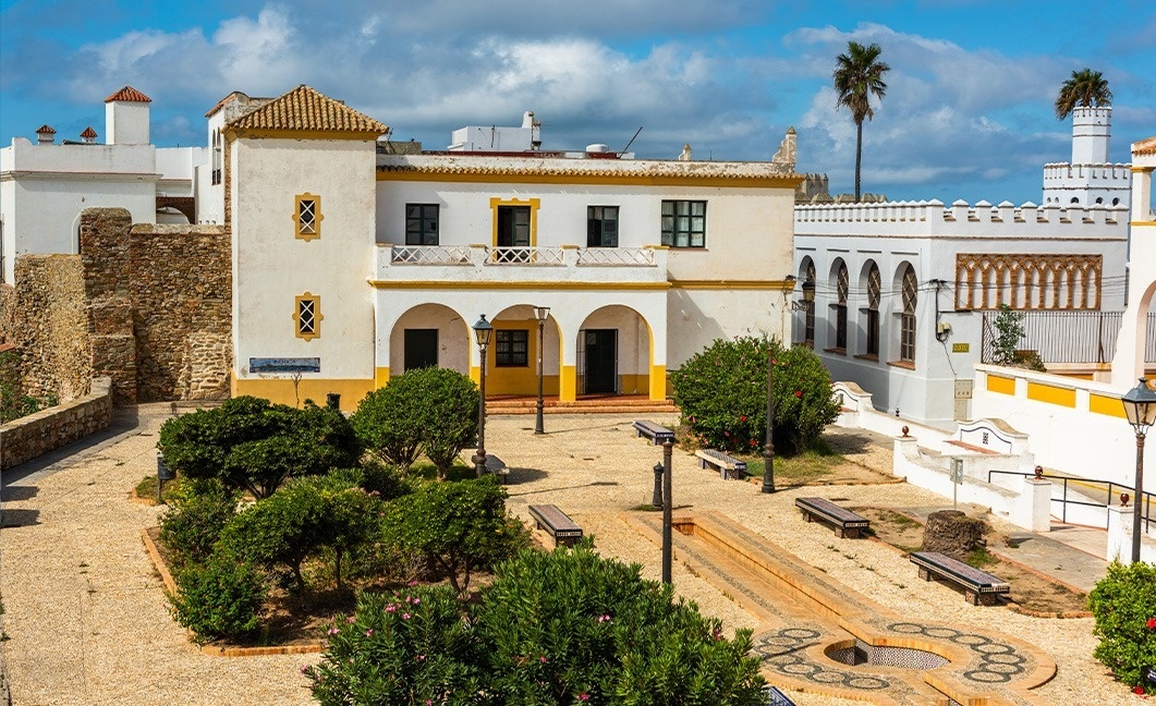 a white building with a yellow trim has a sign that says ' ayuntamiento ' on it