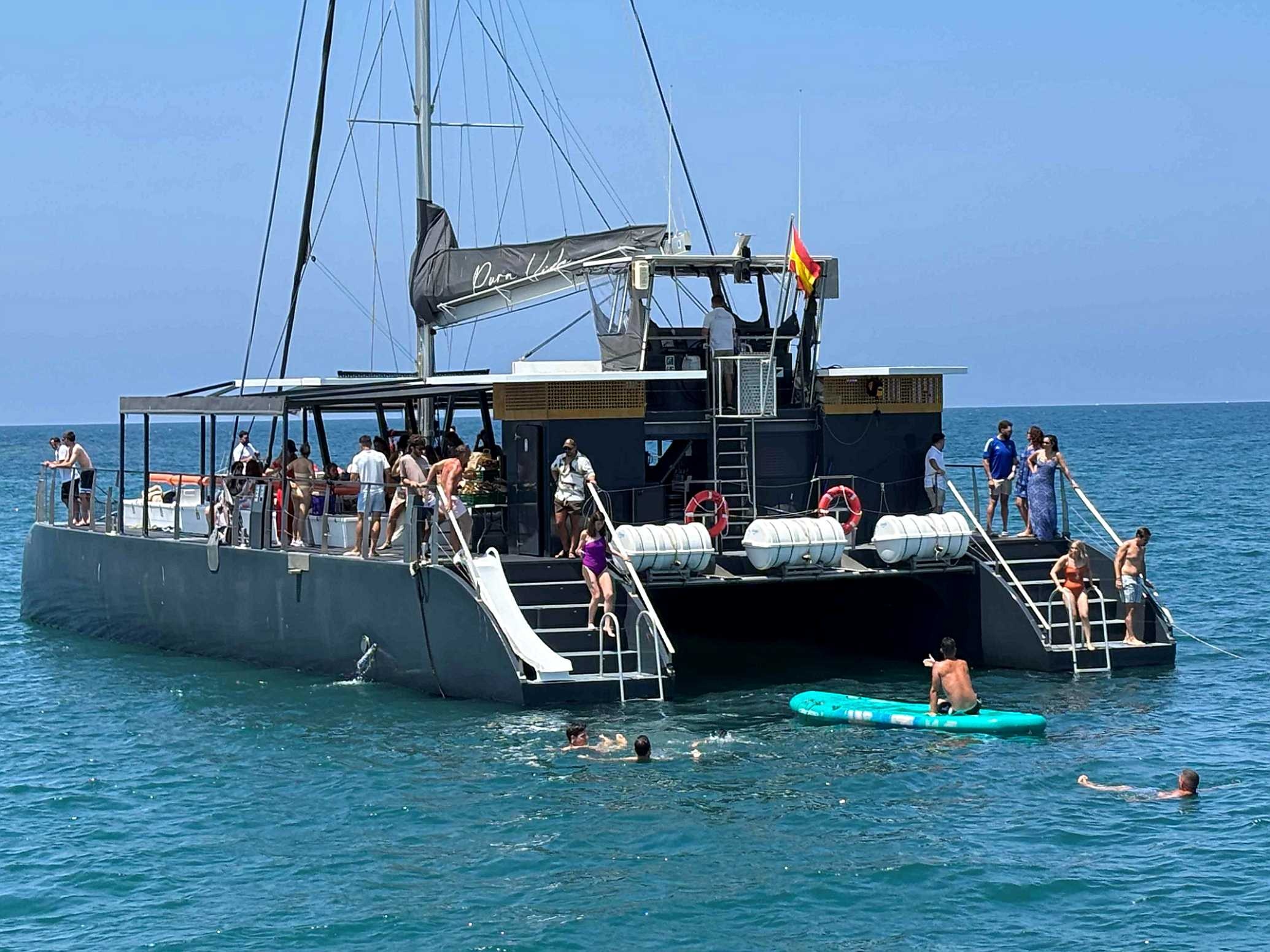 Taiga: Corporativa boat cruise with people swimming and enjoying the water.