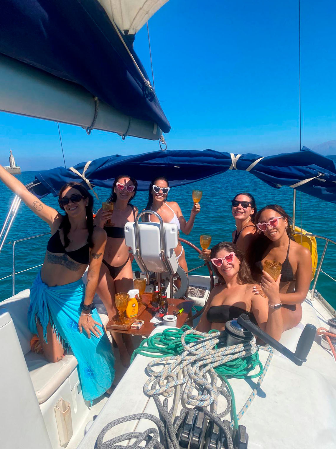 Grup de dones amb ulleres amb forma de cor celebrant en veler, experiència de vacances Taiga: Corporativa.
