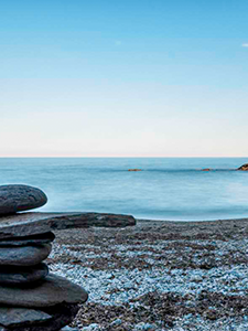 une pile de rochers est empilée sur une plage avec l' océan en arrière-plan .