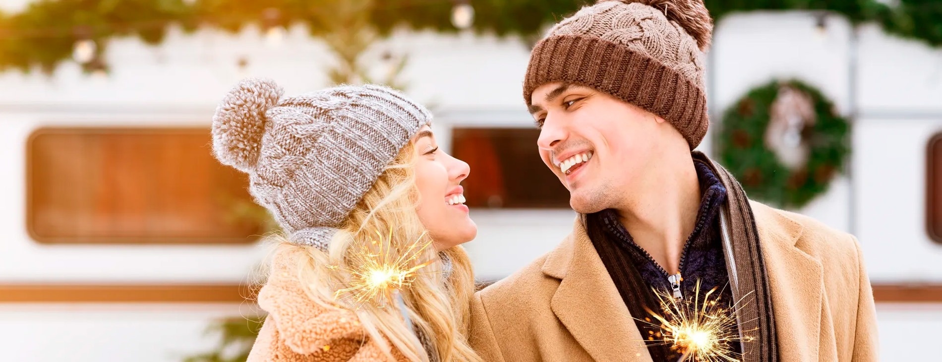 een man en een vrouw kijken elkaar aan terwijl ze sparklers vasthouden