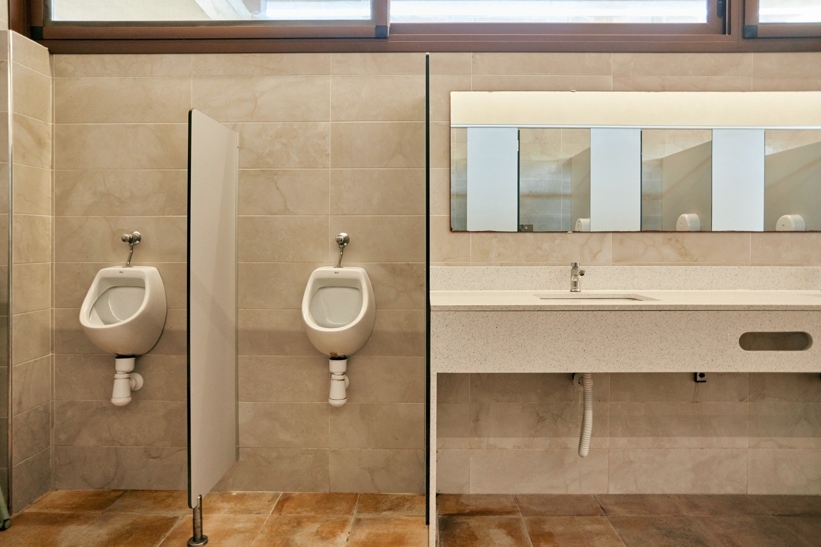 a bathroom with two urinals and a sink