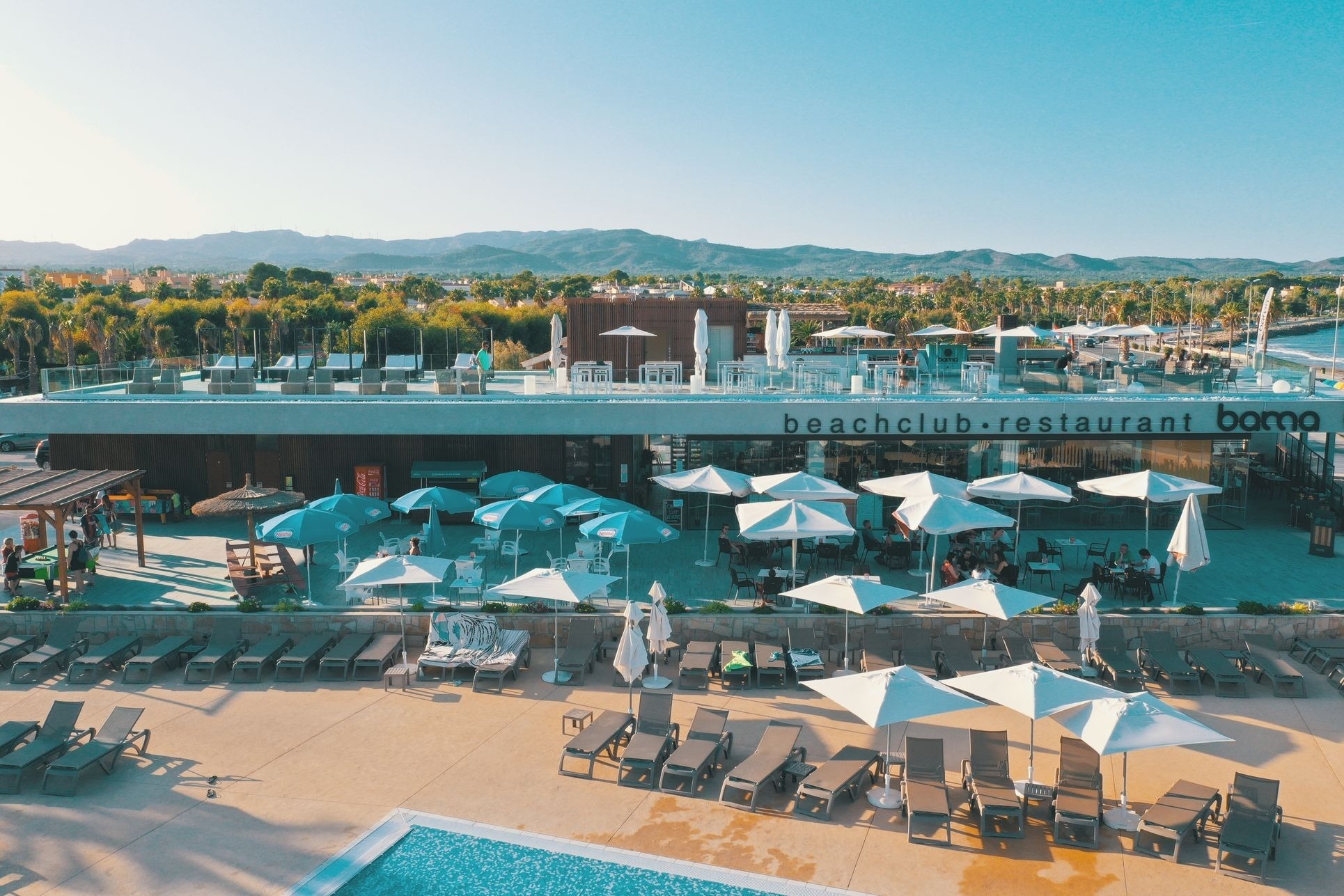een strandclubrestaurant met veel parasols en stoelen