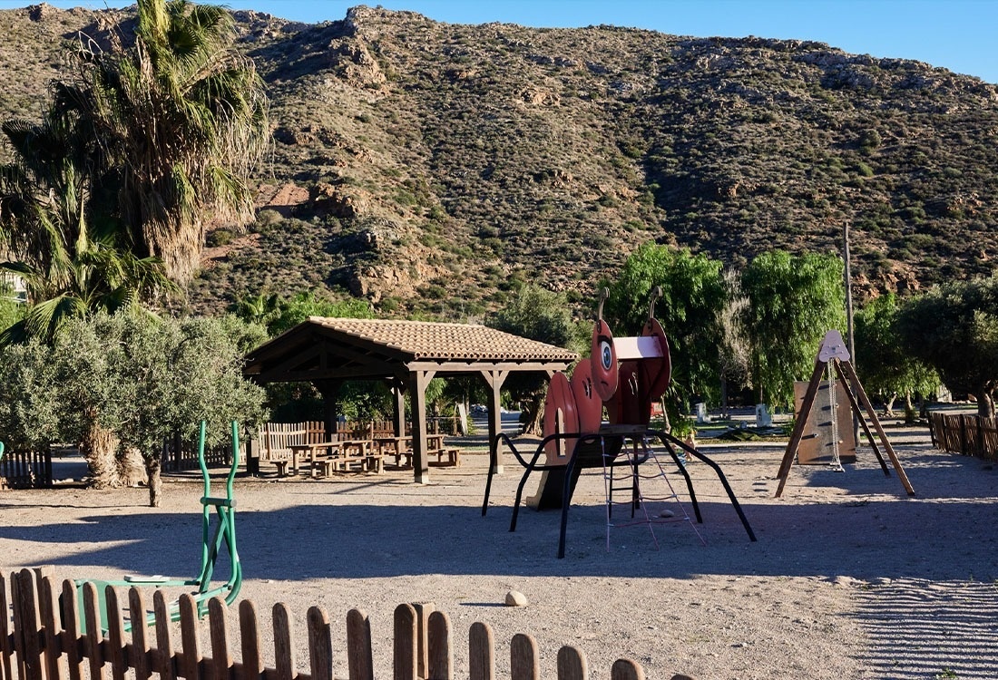 une femme tient un panier bleu rempli de vêtements dans une laverie