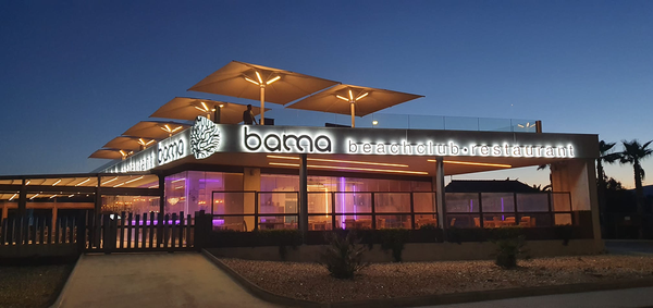 the bama beach club restaurant is lit up at night