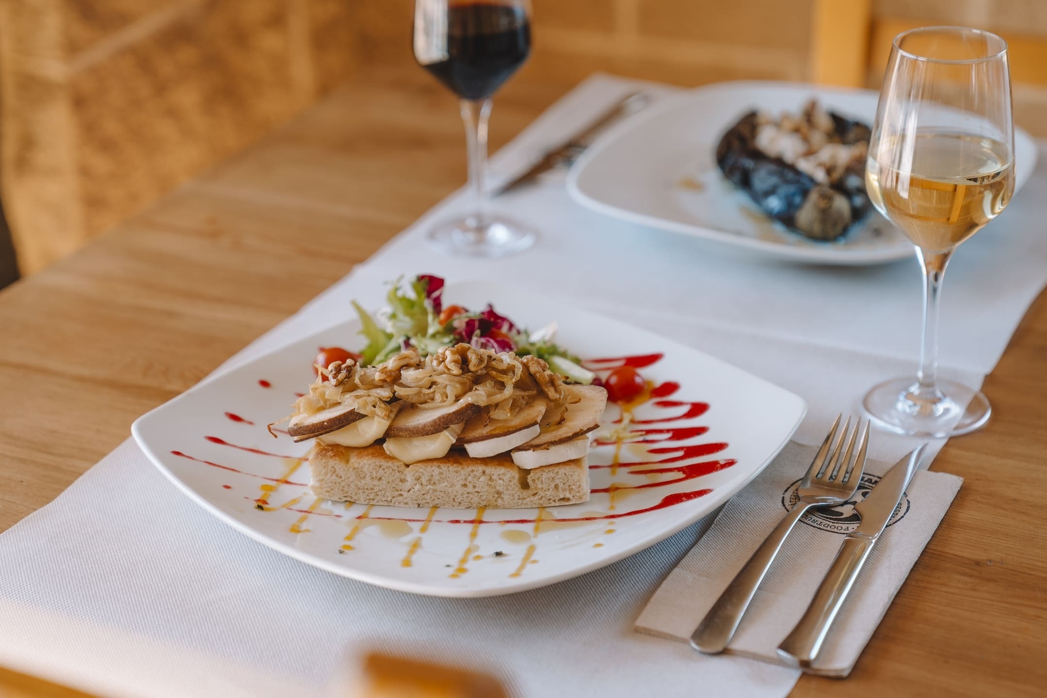 Tostada gourmet de setas, queso y nueces con ensalada, en el elegante restaurante del hotel.