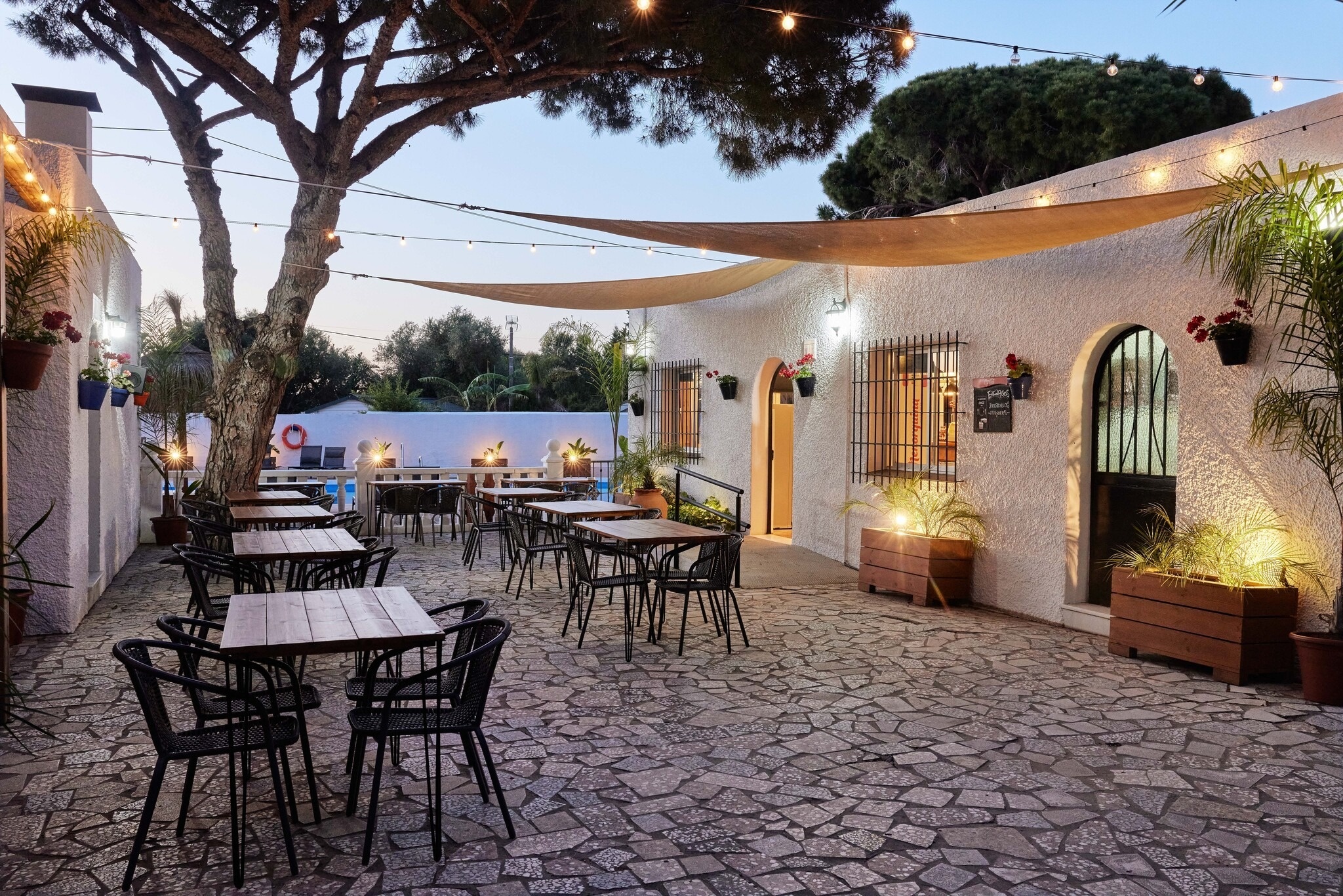 een patio met tafels en stoelen en een menu aan de muur