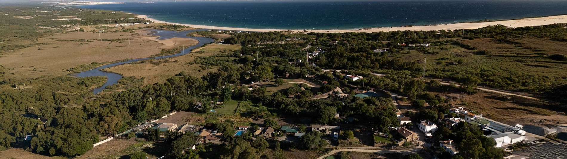 una vista aérea de un pueblo junto a un río y una playa