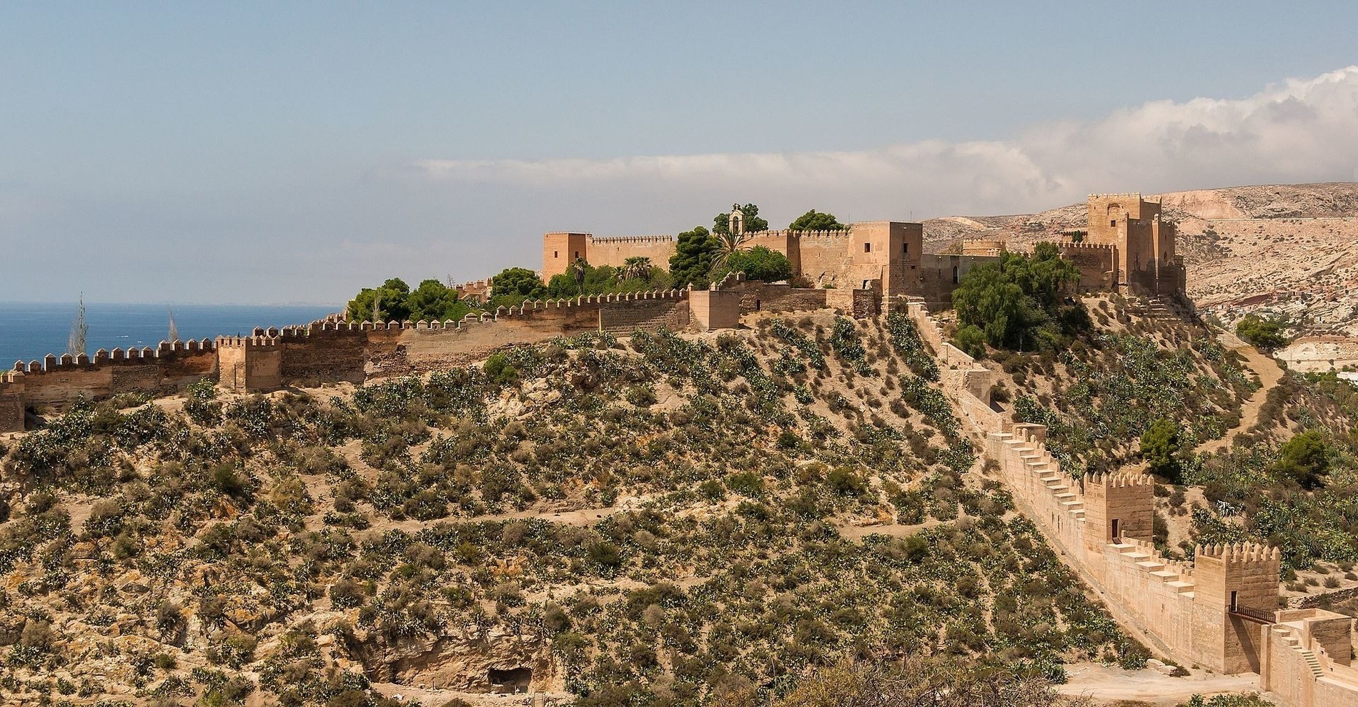 a castle sits on top of a hill overlooking the ocean