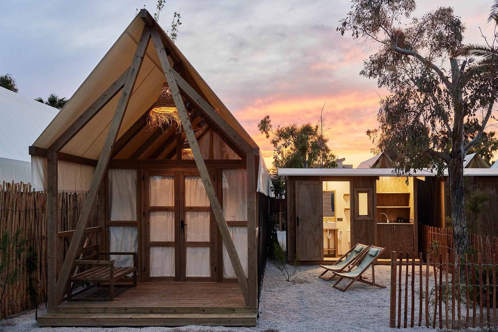a small wooden house with a sunset in the background