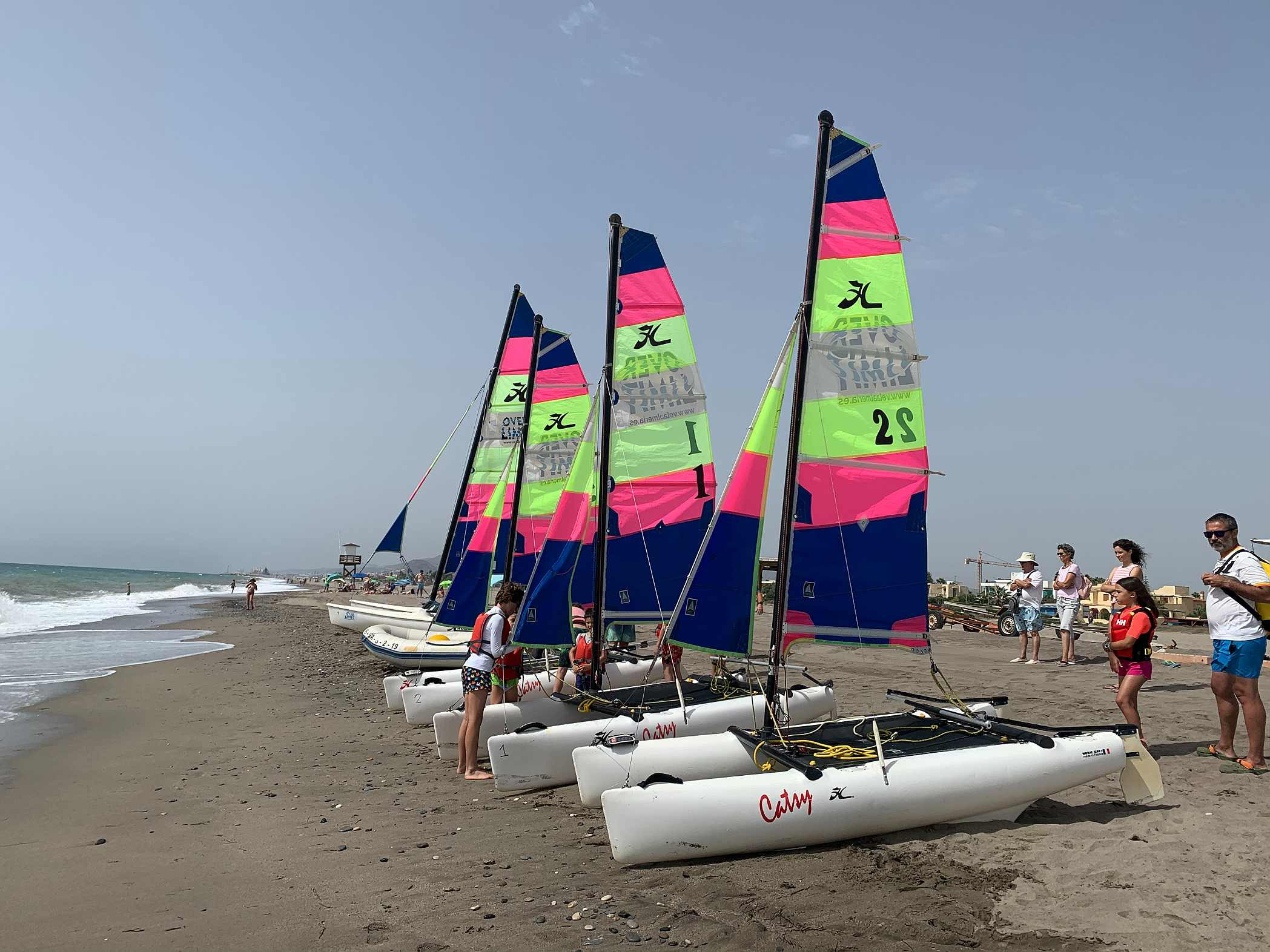 Jóvenes navegando un catamarán en la playa, una actividad Taiga: Corporativa.