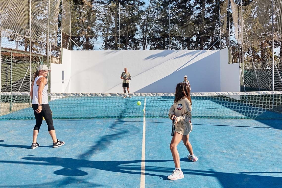 eine Frau und ein Mädchen spielen Tennis auf einem blauen Tennisplatz