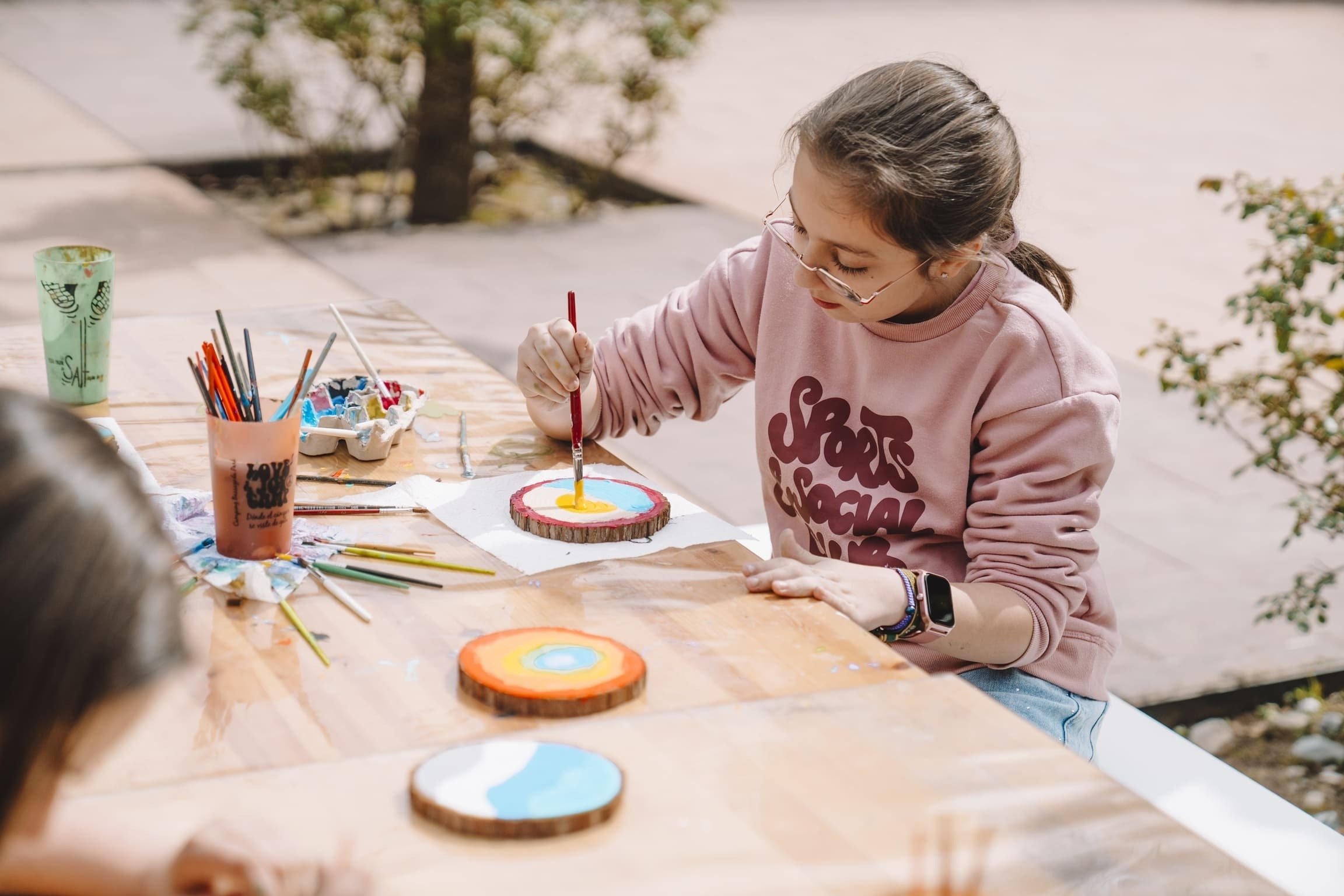 Niña pintando al aire libre en taller creativo del hotel.