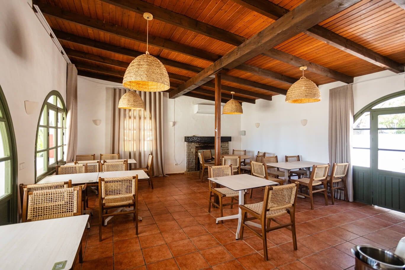 Sala menjador hotelera Taiga: Corporativa amb disseny rústic-modern, bigues de fusta i terra terracota.