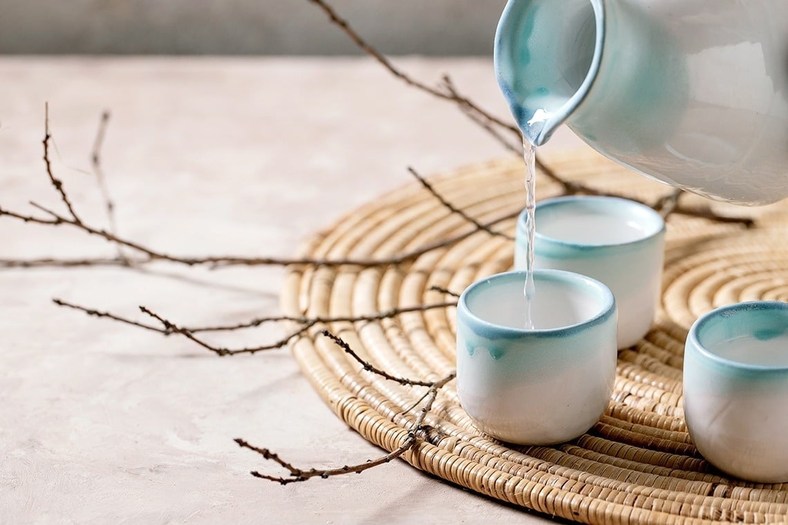 l' eau est versée dans trois tasses bleues et blanches