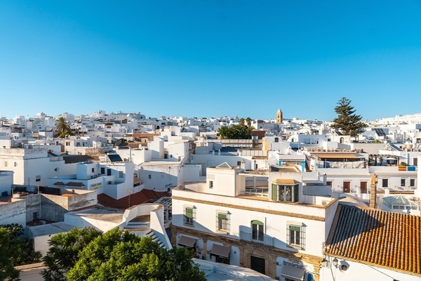 a row of white buildings with a beach in the background