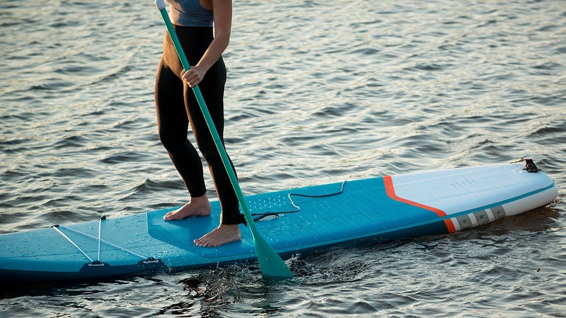 a group of people paddle boarding on a board that says paddles on it