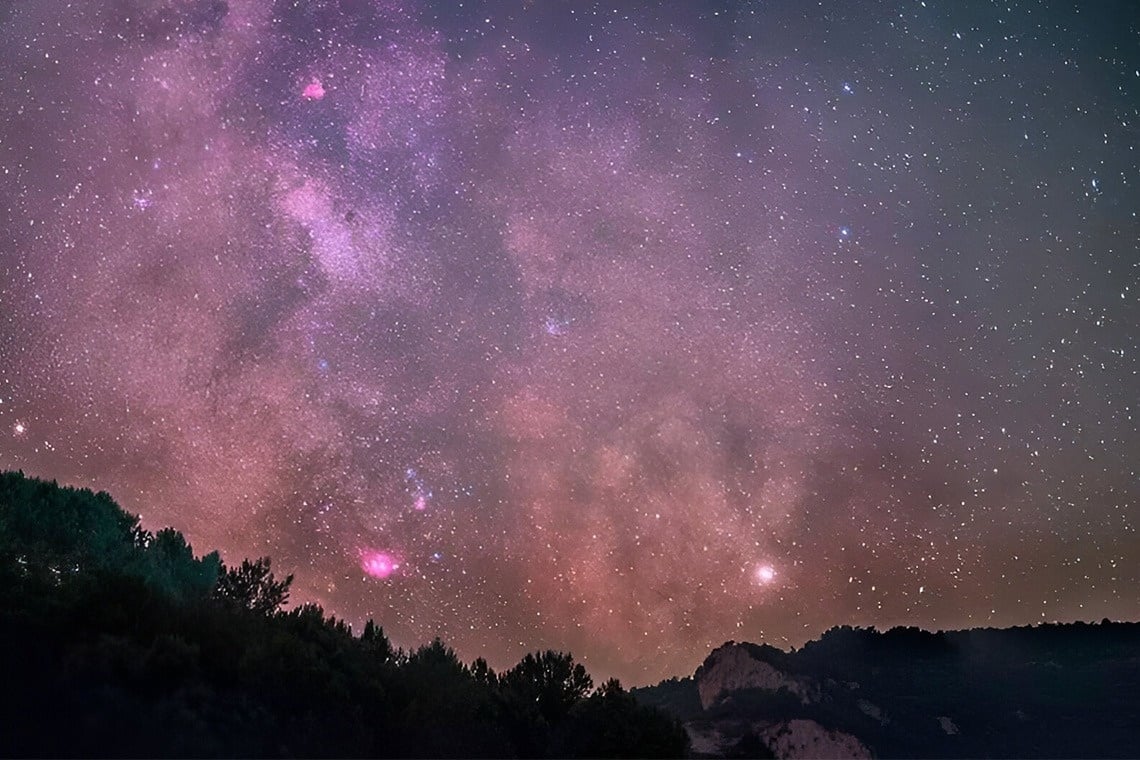 two little girls are running in the grass holding hands