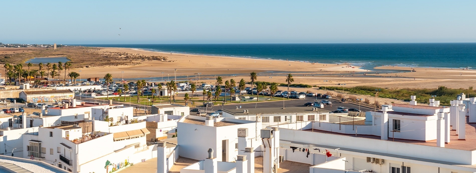 una vista aérea de una playa con edificios blancos en primer plano