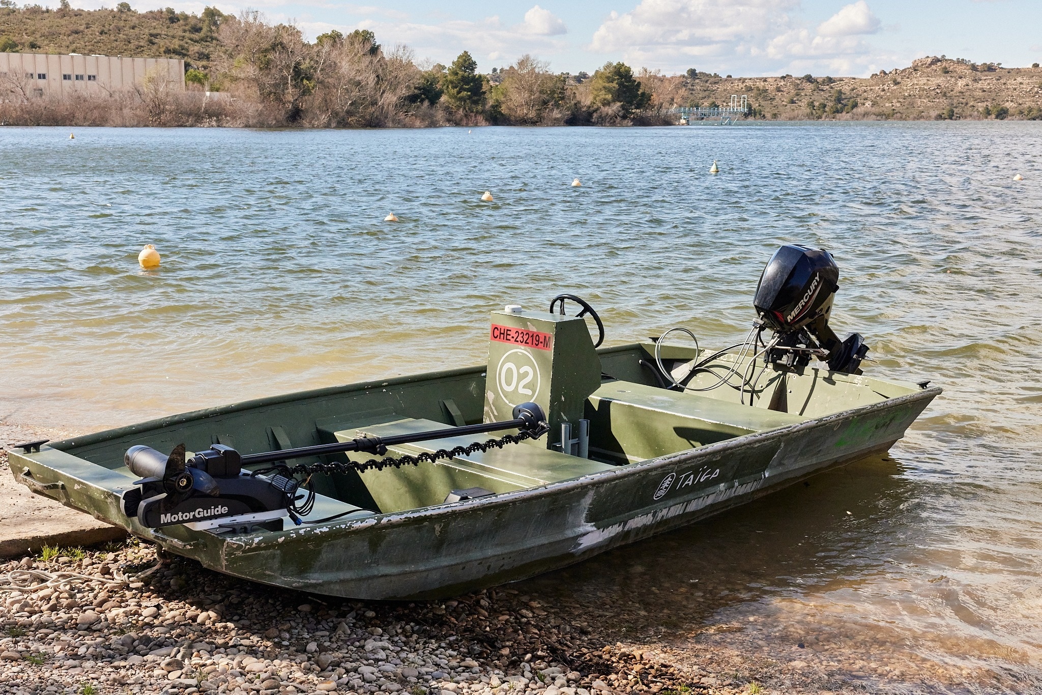 un bote motorguide está estacionado en la orilla de un lago