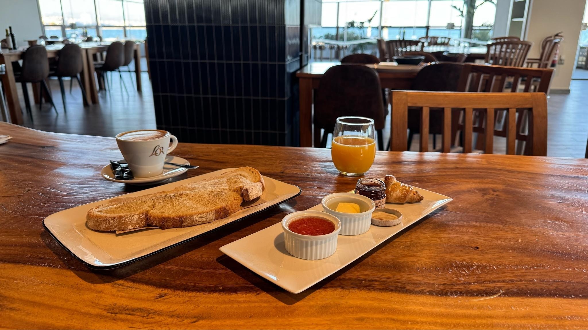 una mesa de madera con dos platos de comida y una taza de café