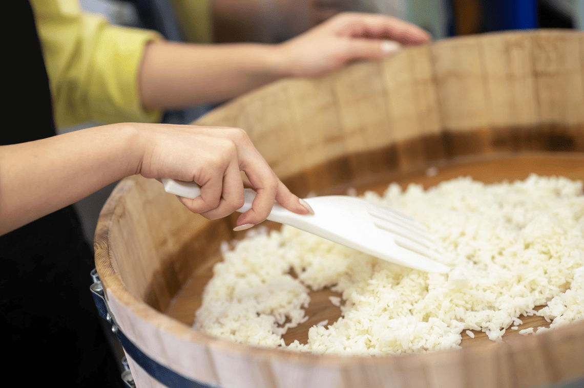 a person is stirring rice in a wooden bowl with a spatula