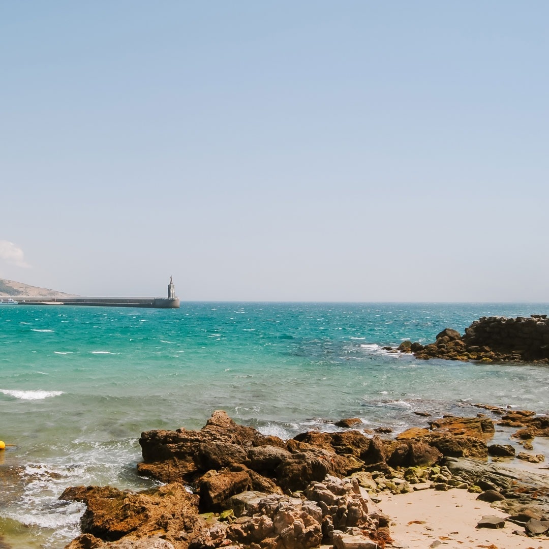 ein Leuchtturm steht an der Spitze eines felsigen Strandes