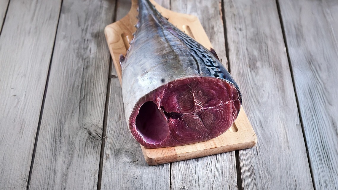 un peix està sobre una tabla de cortar de fusta