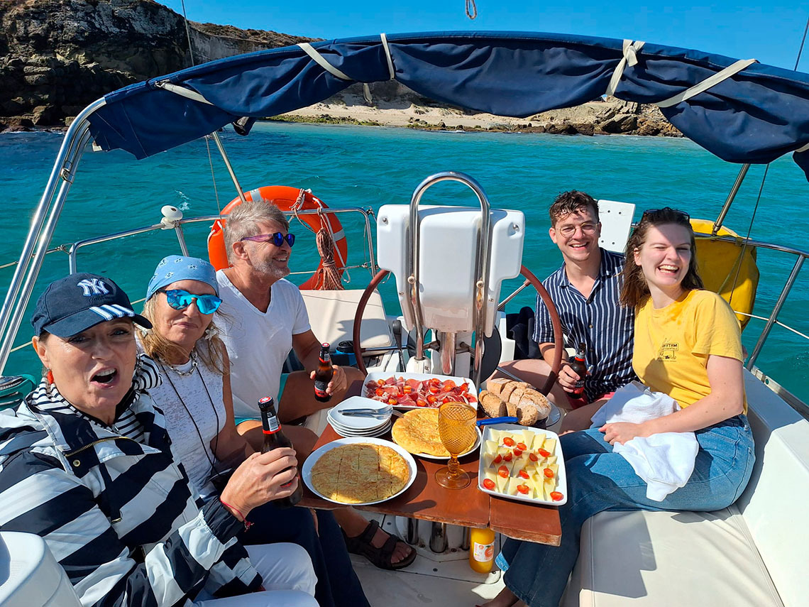 Grup d'amics gaudint d'un aperitiu amb Taiga: Corporativa en un veler amb aigües turqueses.