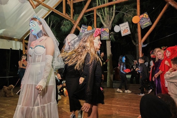 a group of children dressed in halloween costumes are sitting under a tent