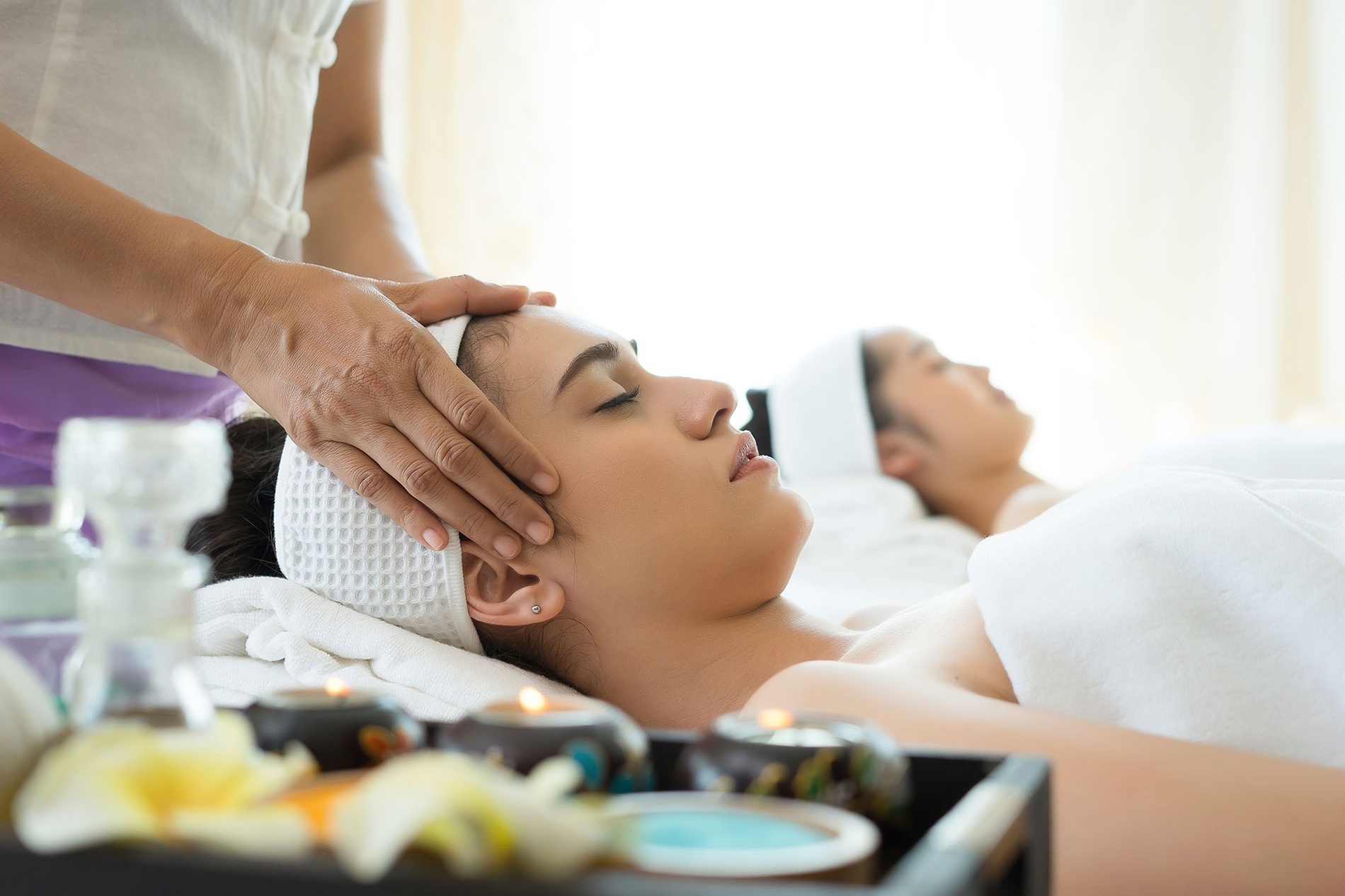 a woman is getting a head massage at a spa