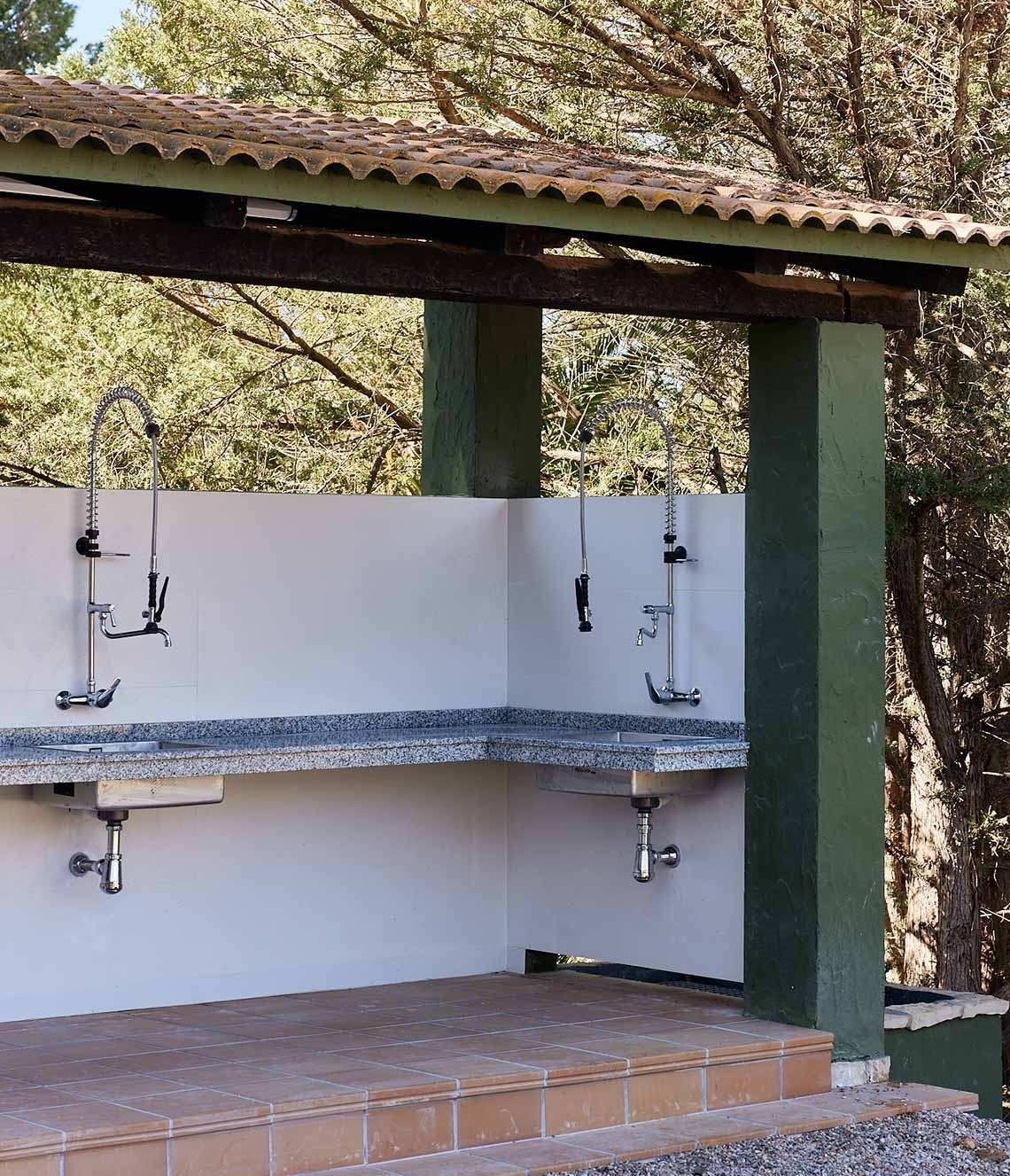 ein Waschbecken unter einem Dach mit zwei Waschbecken darunter