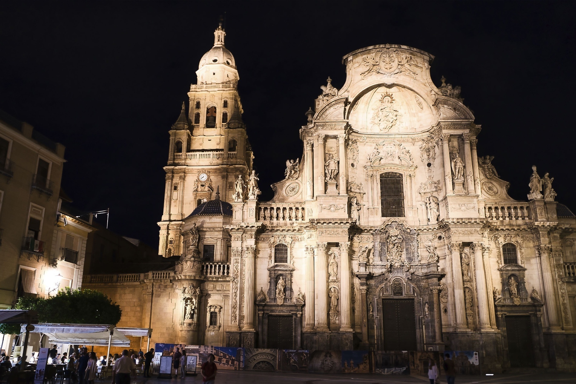 un grupo de personas camina por una plaza frente a una catedral